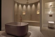 a bathroom lit for night time relaxing with a layered lighting scheme
