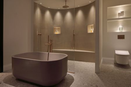 a bathroom lit for night time relaxing with a layered lighting scheme