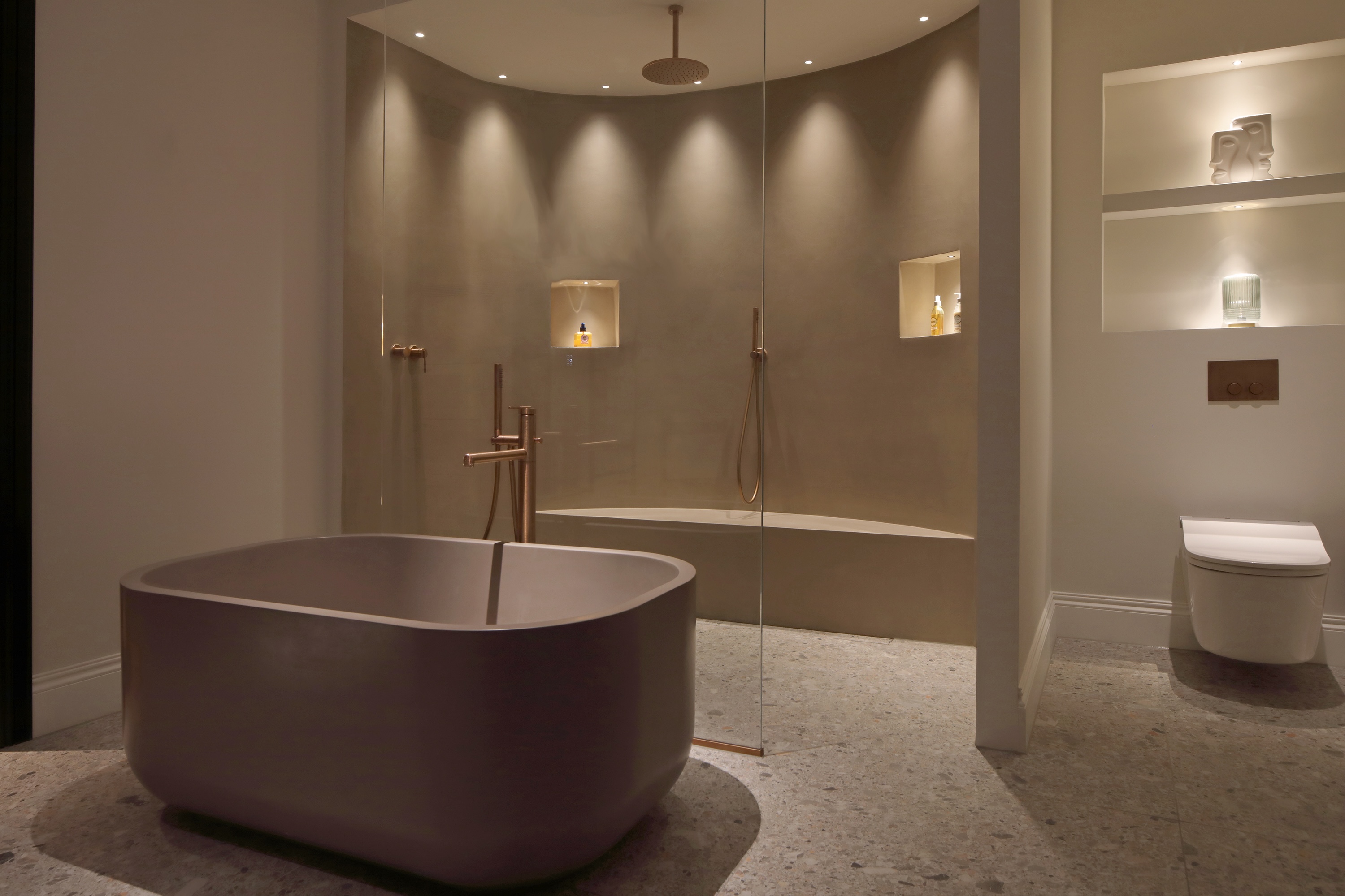 a bathroom lit for night time relaxing with a layered lighting scheme