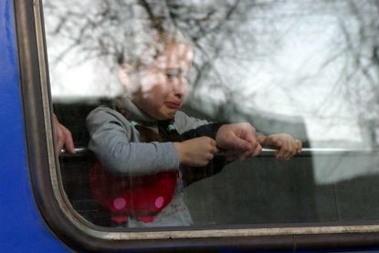 A child cries on a train leaving Odesa for Poland