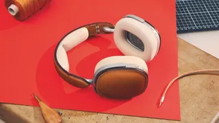 Hermès headphones in brown leather on a red surface