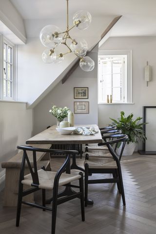 scandi inspired table and black framed wishbone chairs in kitchen with wood floors