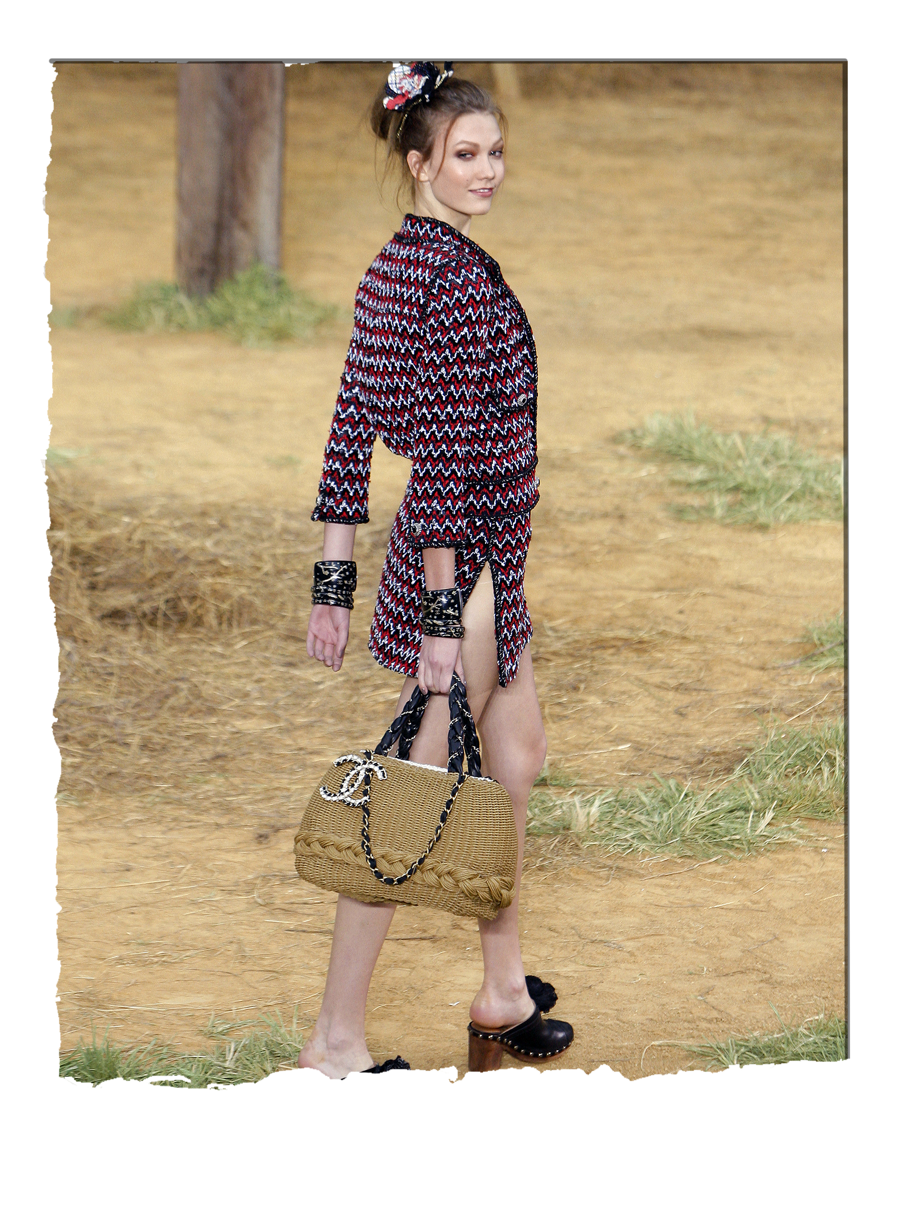 Model Karlie Kloss carries a Chanel basket bag on the runway