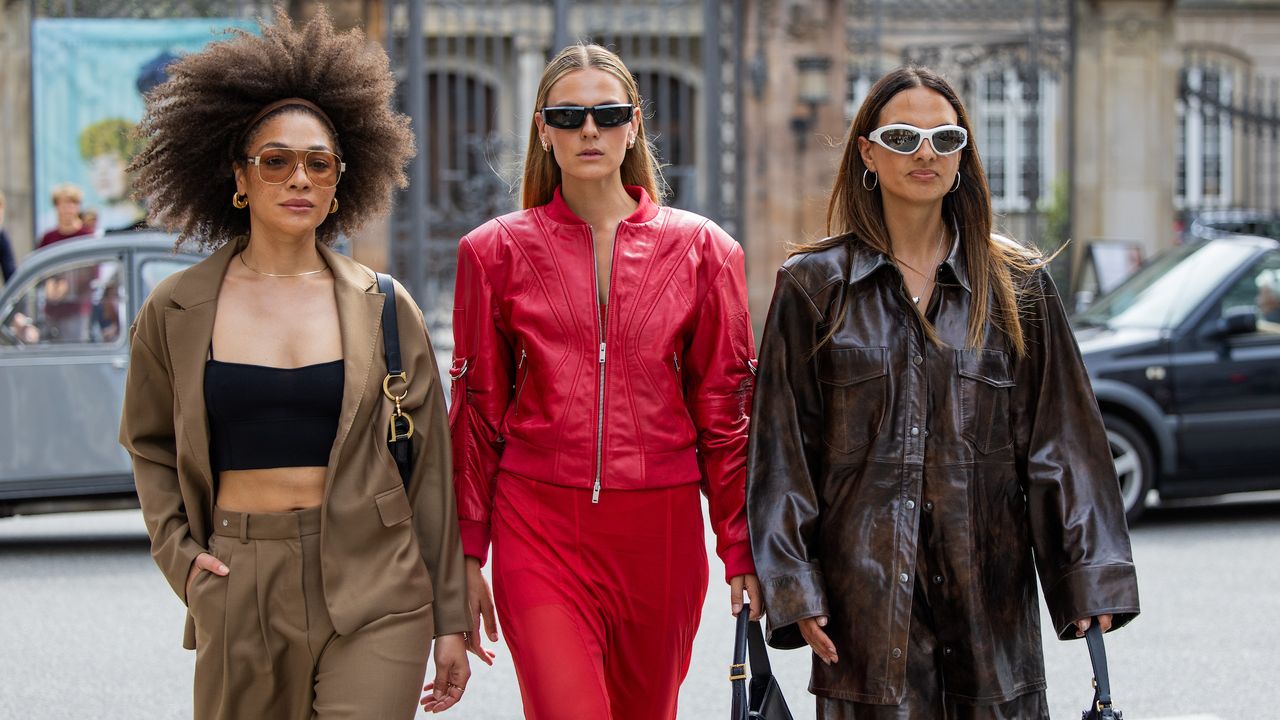 Julia Dalia wears brown blazer, pants, black top &amp; Alessa Winter wears red leather jacket, transparent skirt, black YSL bag, sunglasses &amp; Anna Winter wears brown oversized jacket, black bag - getty images 2166017927