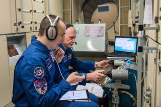 Russian cosmonauts Pyotr Dubrov and Oleg Novitskiy complete an exam before their launch, scheduled for late April.