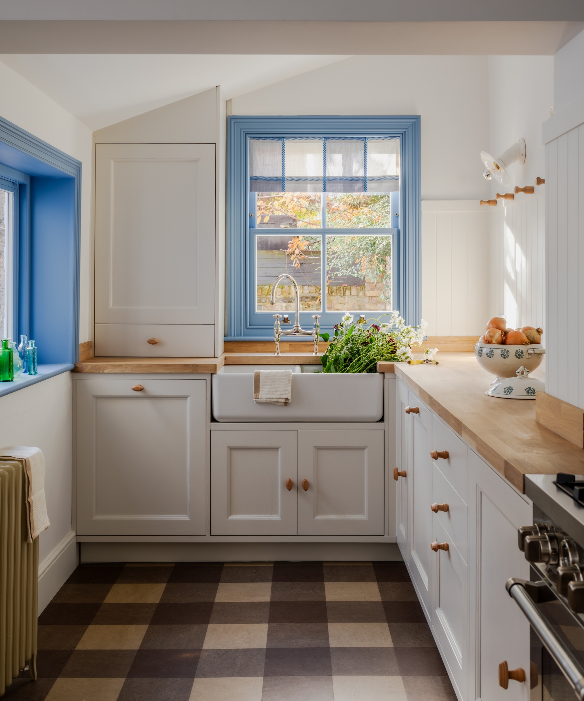 A small white kitchen with gingham floor tiles