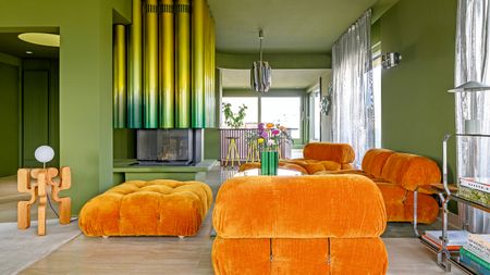 Matcha green living room with ombre irridescent yellow-green tubular fireplace, orange velvet sofas and freestanding wood sculptural floor lamp