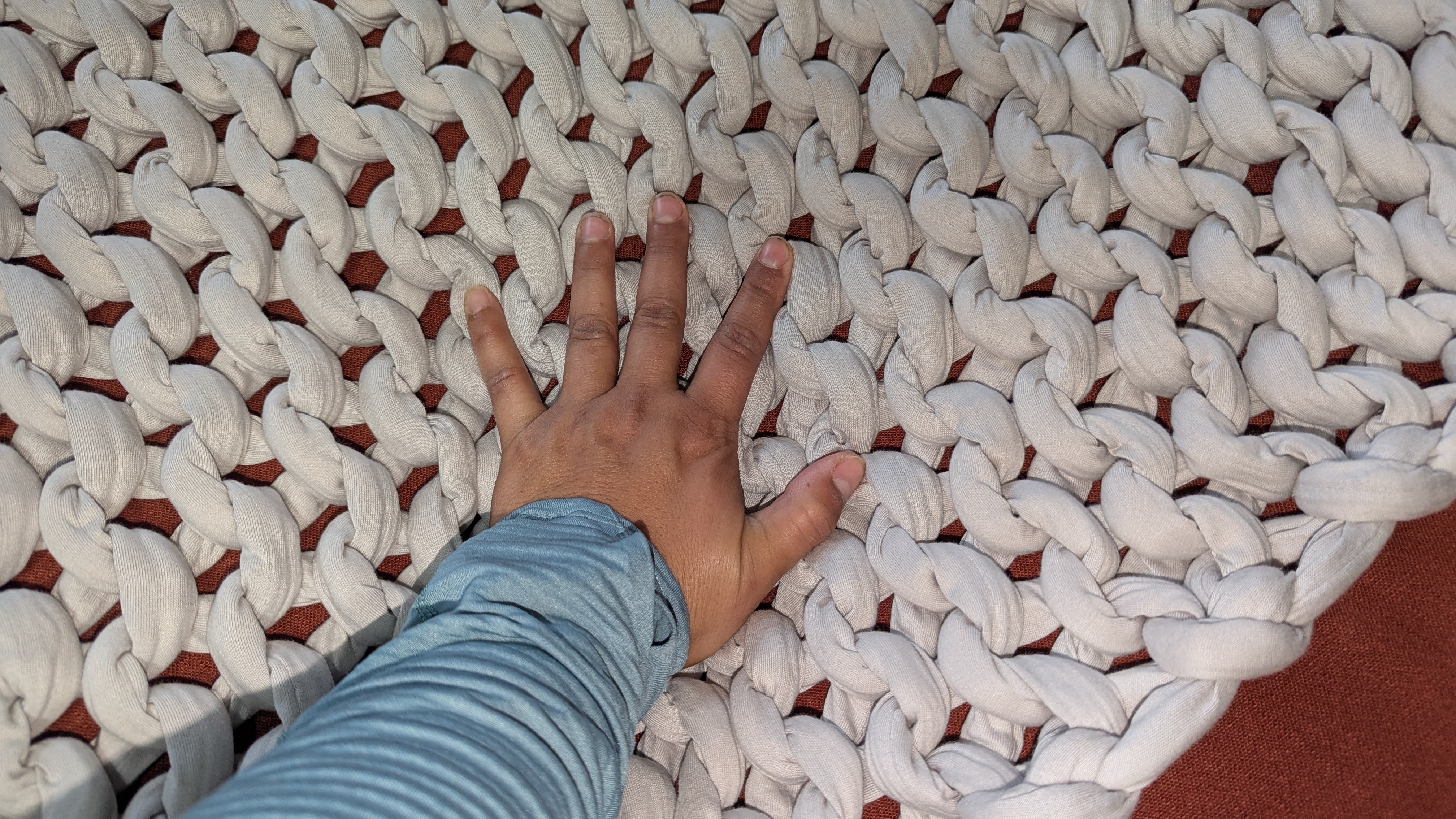 Hand placed on the knitted weighted blanket