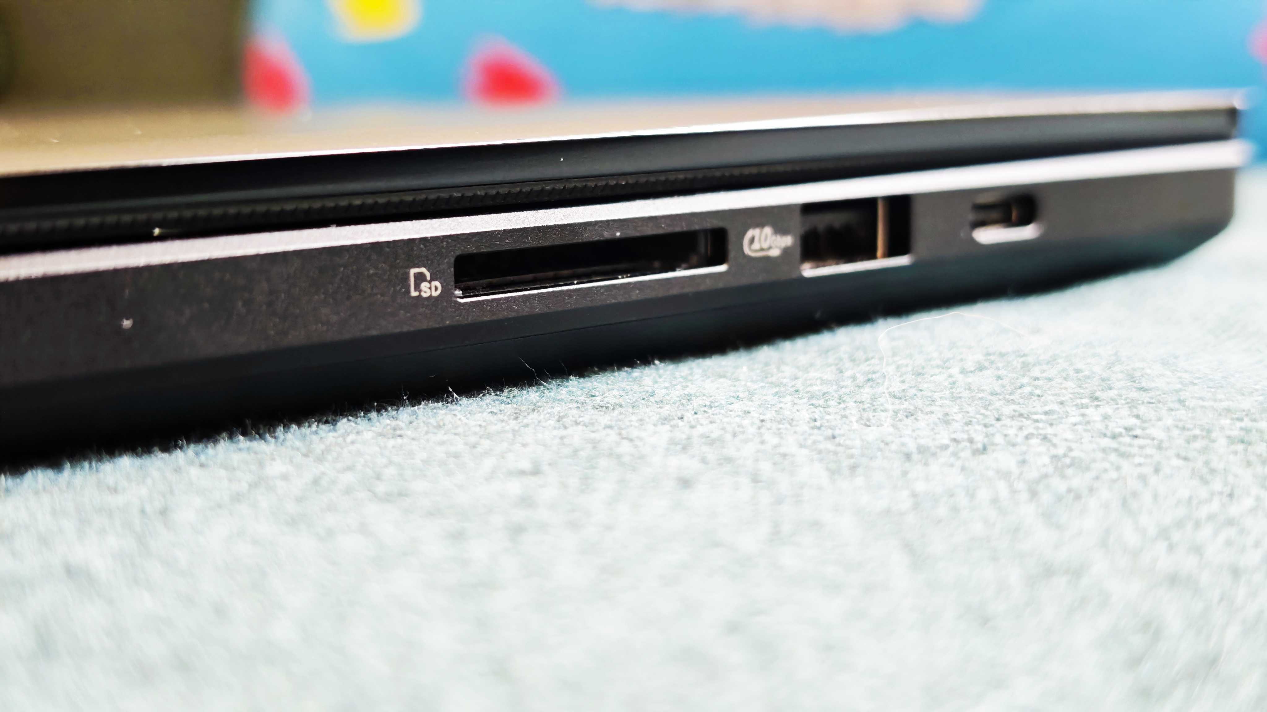 A black ASUS ProArt P16 laptop on a green sofa