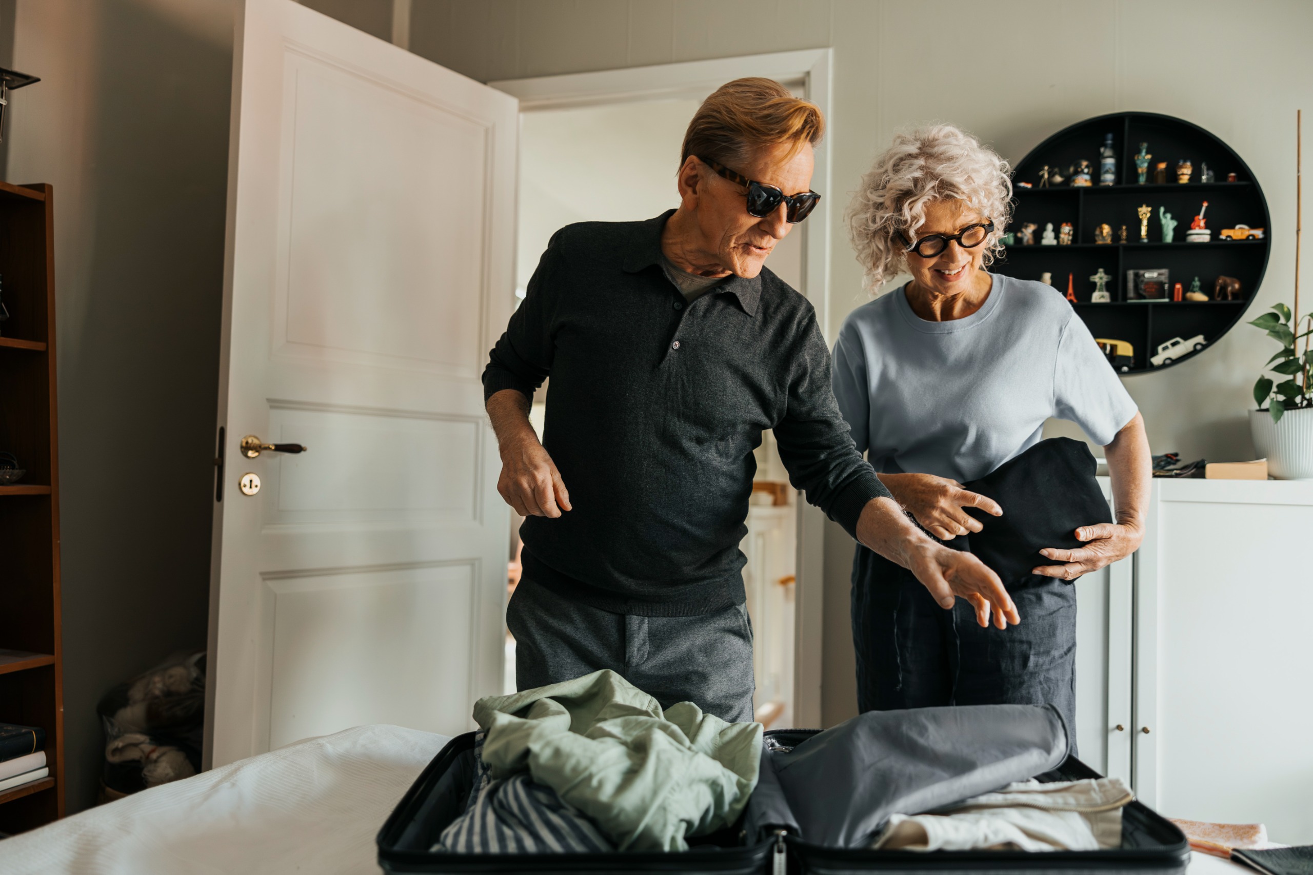 A mature couple discuss how to pack a suitcase for their trip.