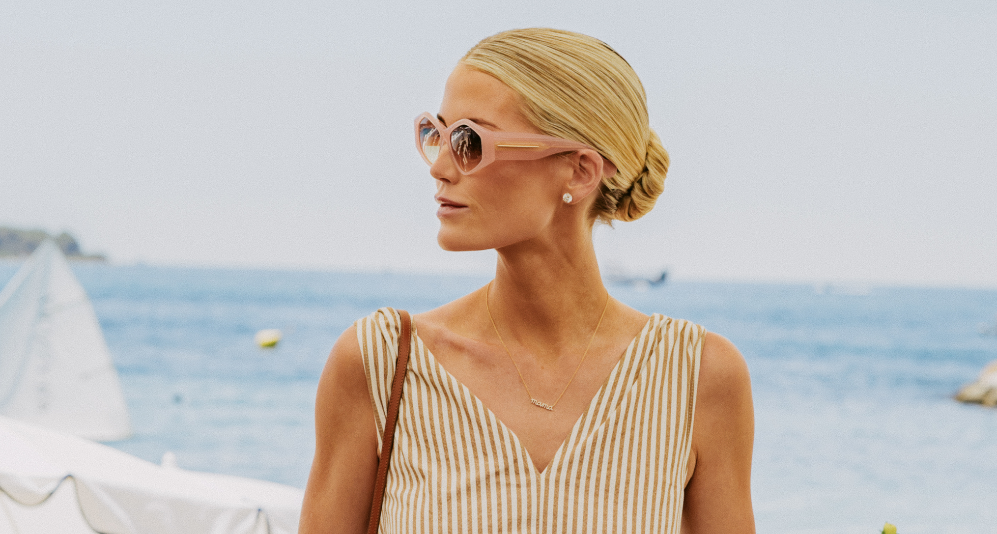 Kitty Spencer turning to the side wearing sunglasses and a striped dress