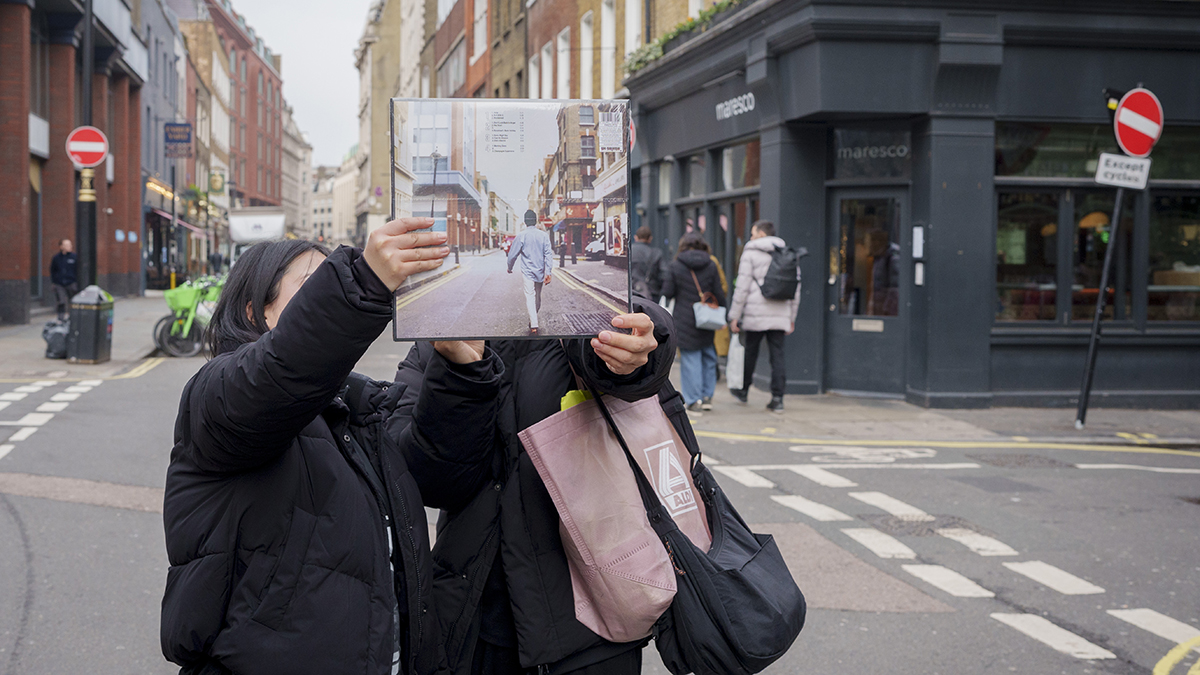 Two people hold up their vinyl copy of the Oasis record cover, 'What's the Story Morning Glory' on Soho's Berwick Street, on 26th January 2026, in London, England.