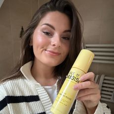Tori Crowther holding a bottle of Isle Of Paradise Express Mousse