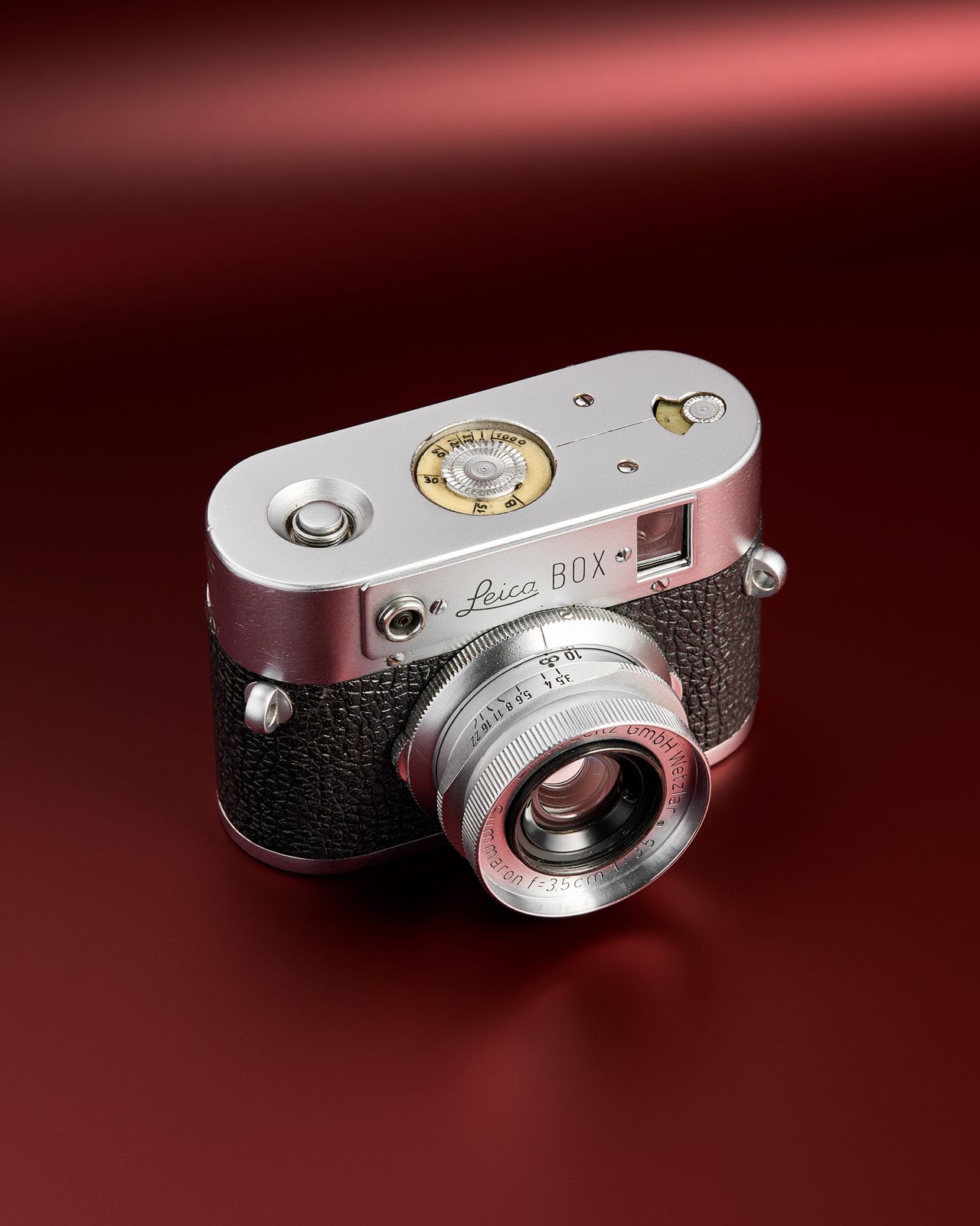 The working Leica Box camera prototype from the mid 1950s on a red background