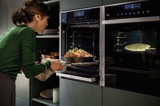 Woman sliding food into a NEFF oven