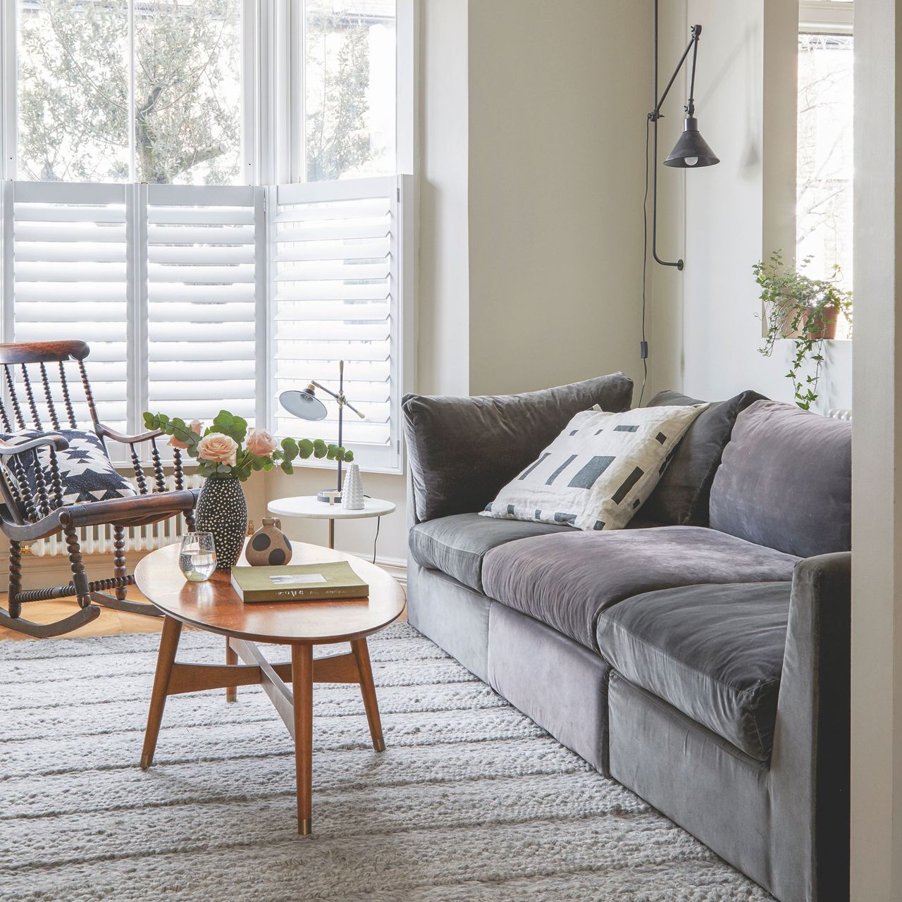 Beige painted living room with a grey sofa and a wooden coffee table in front it