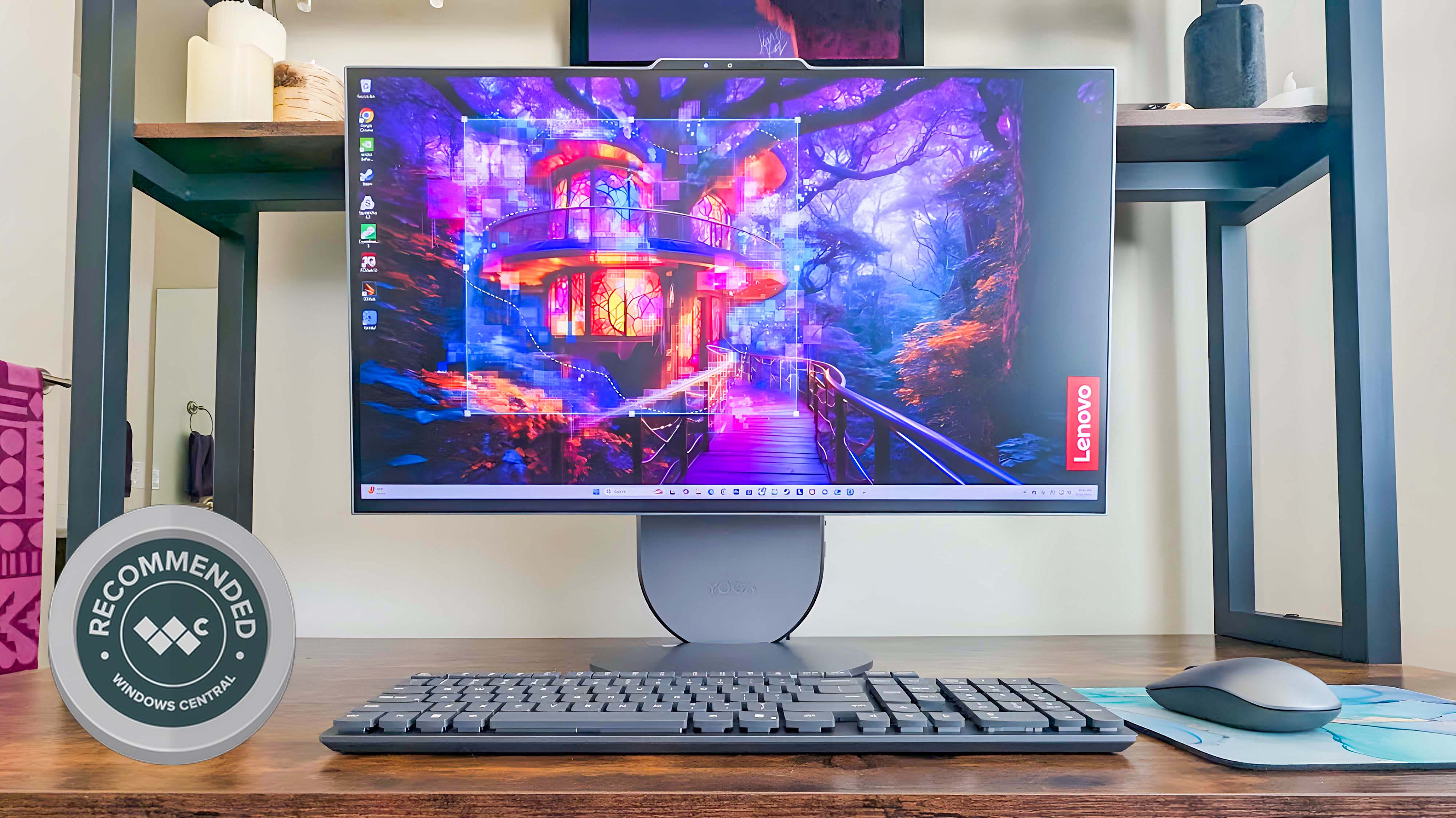 The Lenovo Yoga AIO 27&quot; sitting on a desk. The background on the screen shows a vibrant purple forest with a treehouse. There is a graphic on the bottom left corner of the image that reads, &quot;Recommended Windows Central.&quot;
