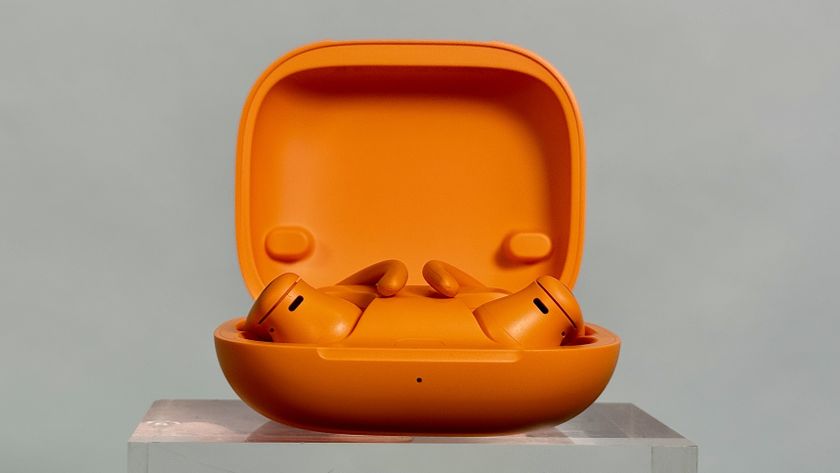 Beats Powerbeats Pro 2 in orange in the charging case with the lid open to reveal the earbuds