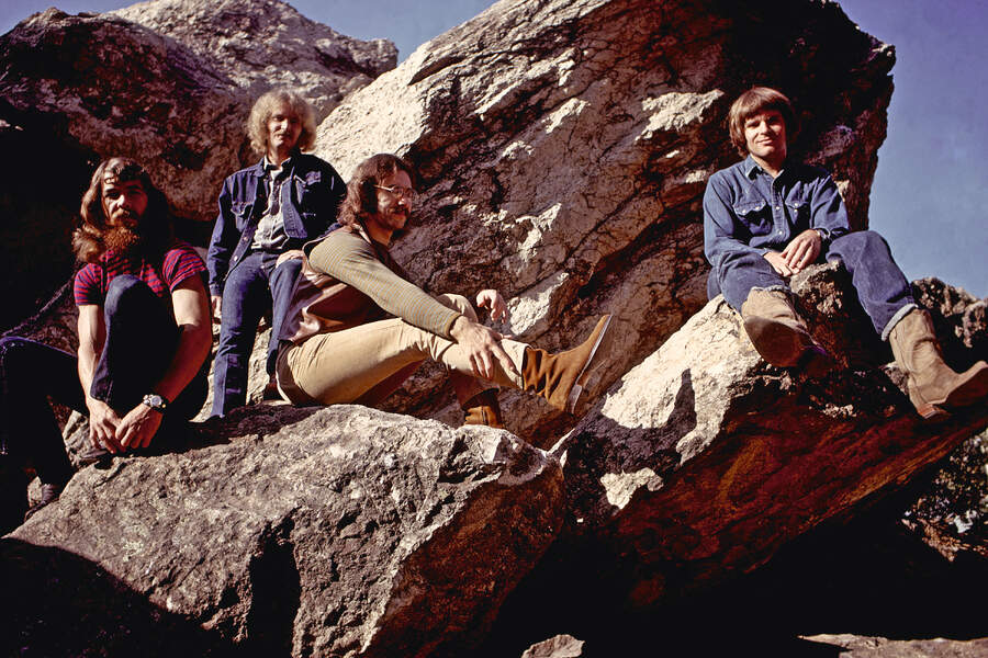 Creedence Clearwater Revival siting on some boulders