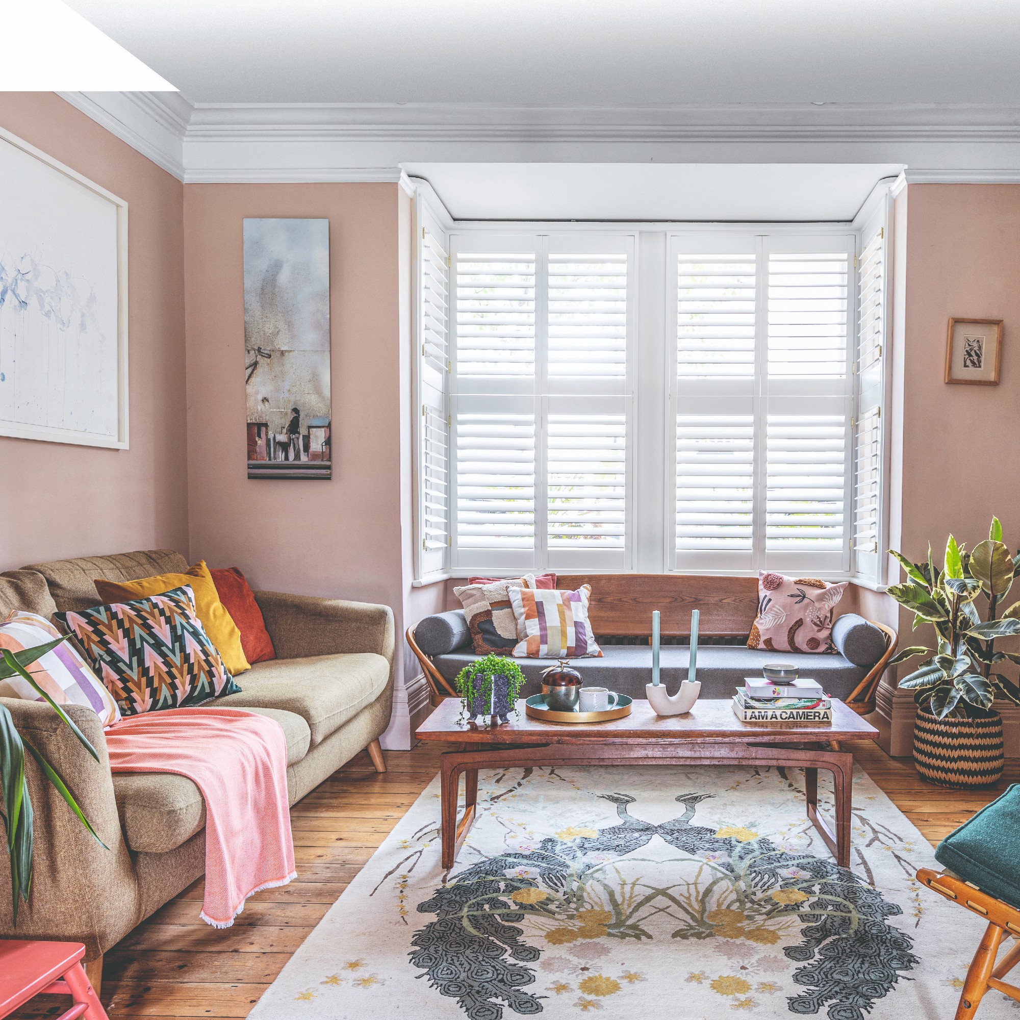A living room with blush pink walls and a white ceiling