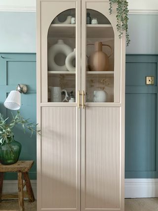 A storage cabinet in a muted tone, with a fluted exterior