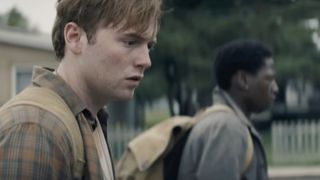 An exhausted Cooper Hoffman walking in The Long Walk