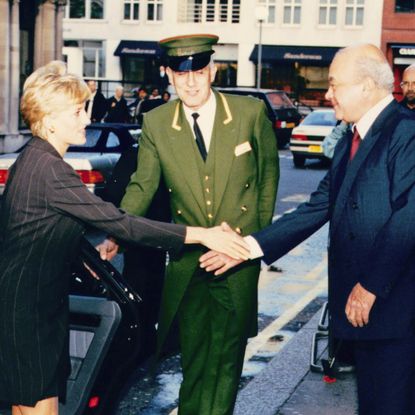 Princess Diana shaking hands with Mohamed Al Fayed next to a Harrods valet