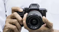 A pair of hands holding the Sony Alpha a7 II mirrorless cam and pointing it towards the viewer