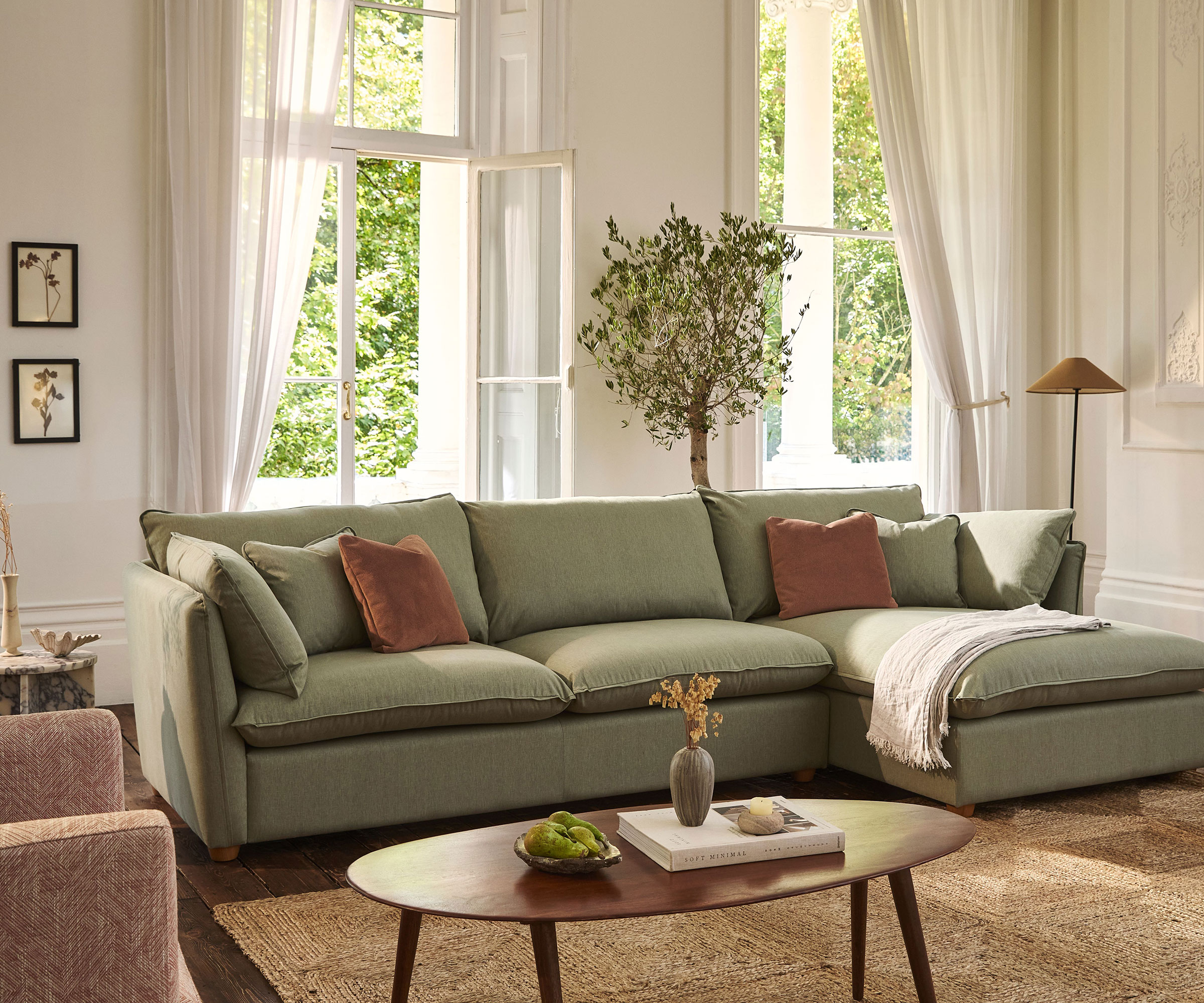 classic living room with large windows and green L-shaped sofa