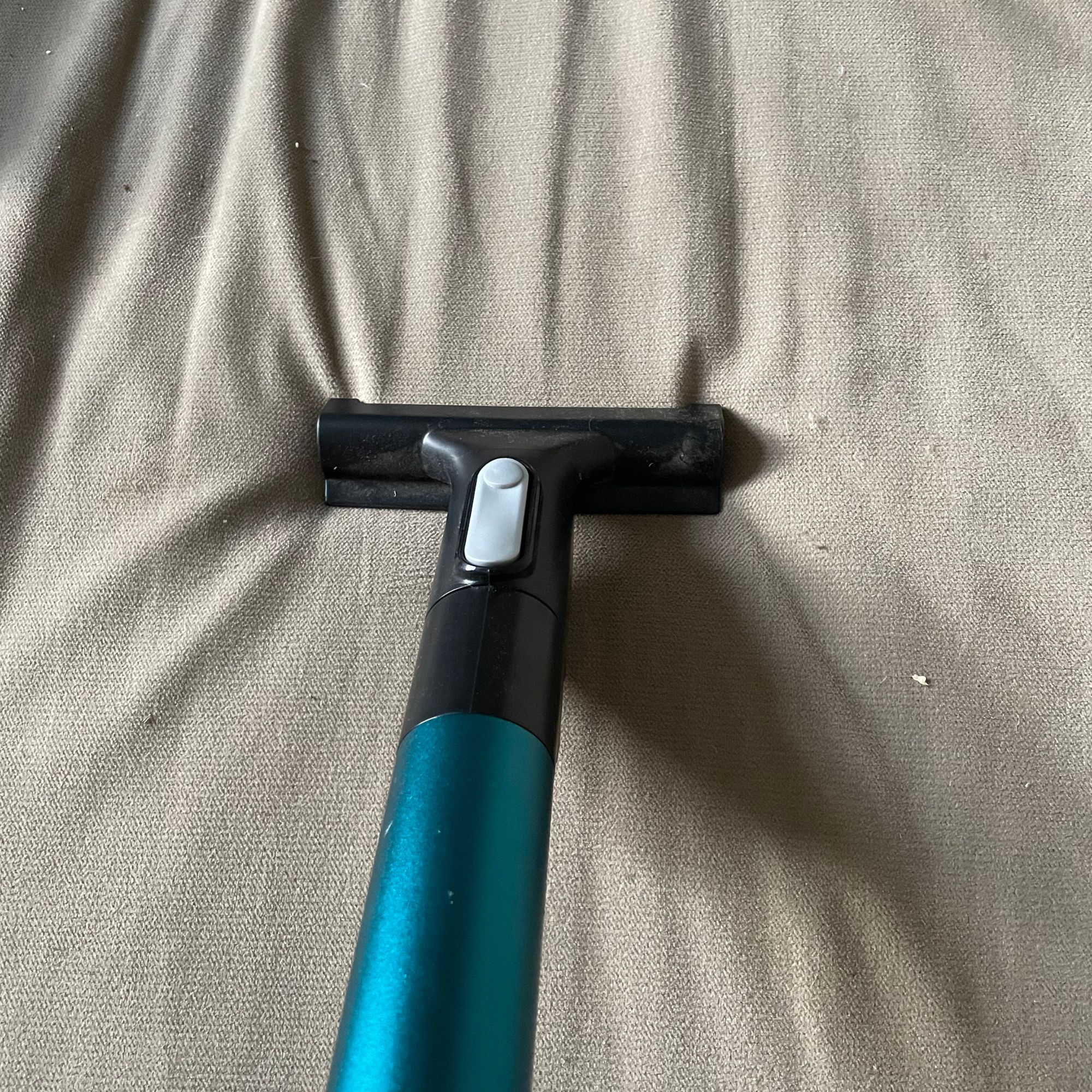 Cleaning a beige sofa with the Vax LiftOut Reach Pet Design Vacuum Cleaner