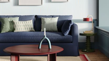 blue sofa in living room with throw pillows and sculptural candlestick
