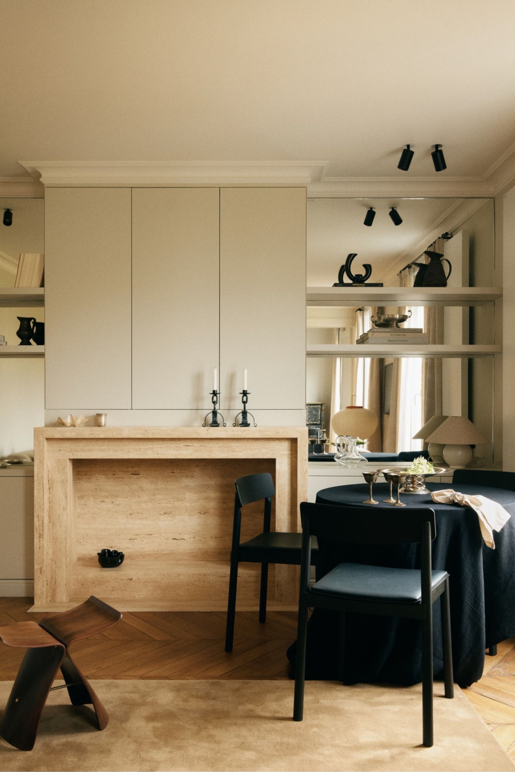 Small apartment with travertine fireplace, black dining room and mirrors