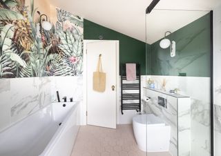 A. modern family bathroom with palm wallpaper, dark green walls and pink floor tiles