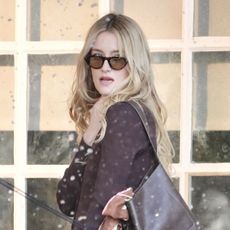 An image of Sarah Pidgeon wearing a knit dress and knee-high boots.