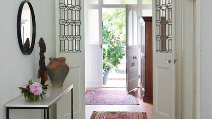 entryway with front door open and red persian rugs