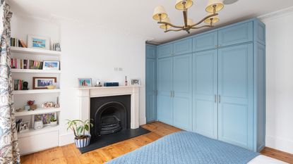 bedroom with blue fitted wardrobes and fireplace