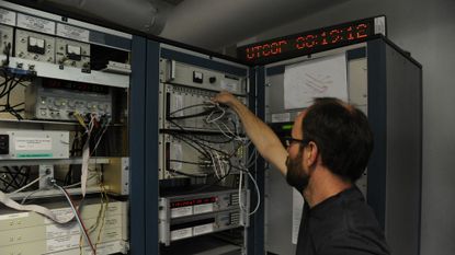 A man works on a coordinated universal time clock in Paris.