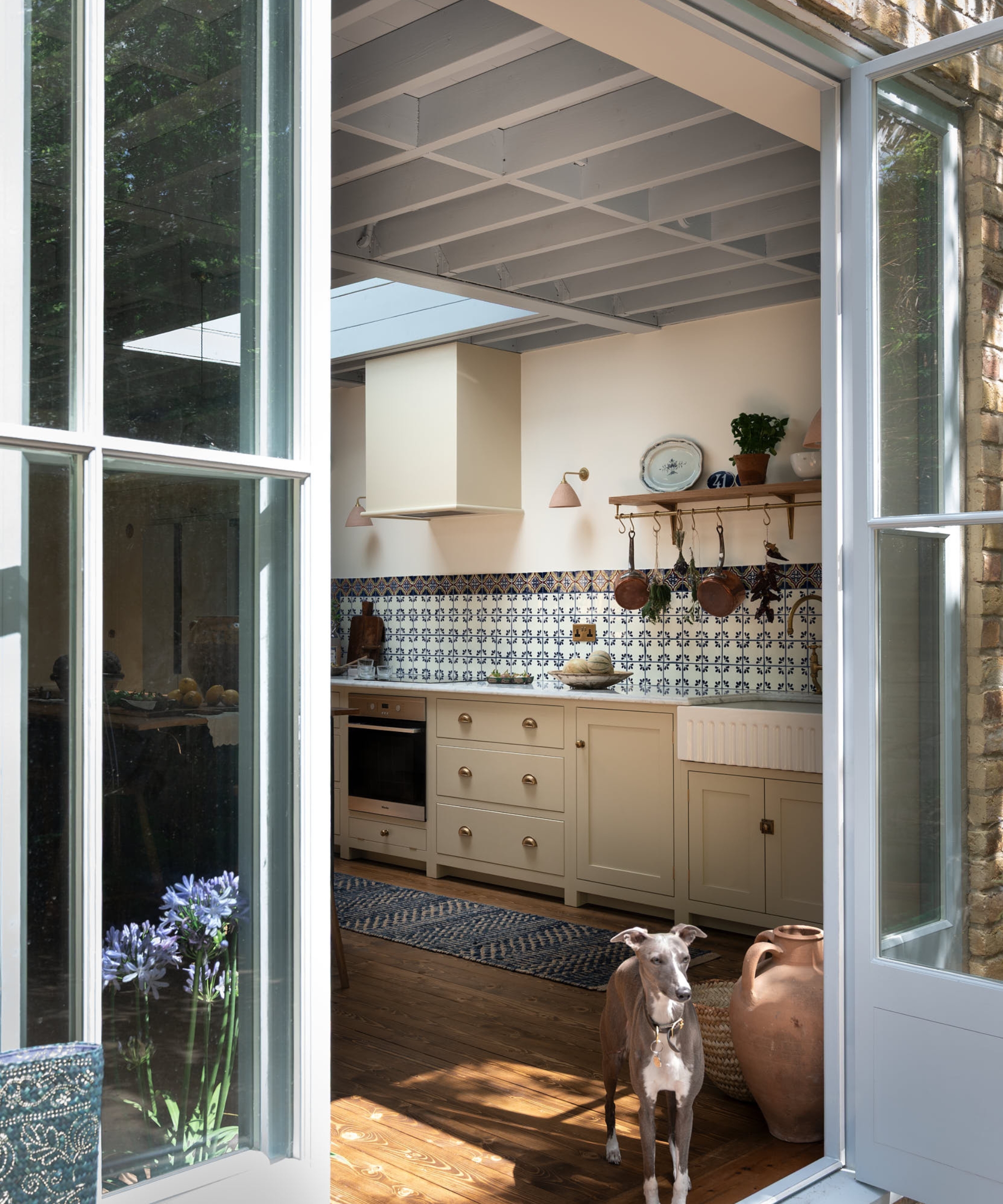 an English kitchen with cream cabinets, white walls, and a blue ceiling