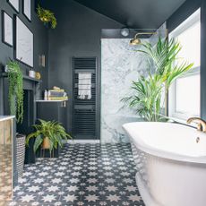Blue bathroom with white bath and shower enclosure and patterned tiles
