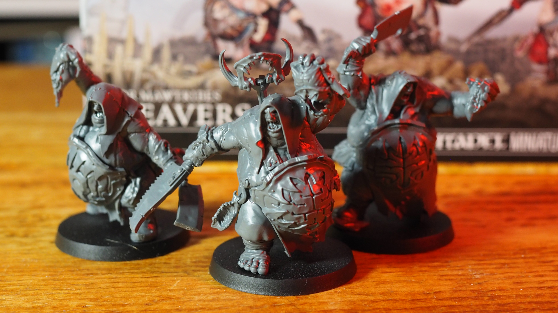 Three Gutseer models in front of the Cleavers box, on a wooden surface