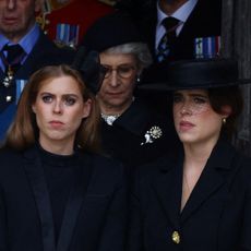 Princess Beatrice and Princess Eugenie both look serious while wearing black outfits