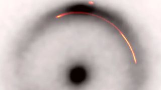 A black and white image of an Einstein ring with a red a yellow arc highlighted within its halo