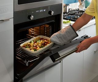 food being taken out of built-in oven