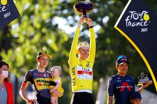 PARIS FRANCE JULY 18 Jonas Vingegaard of Denmark and Team JumboVisma and his daughter Frida Tadej Pogaar of Slovenia and UAETeam Emirates Yellow Leader Jersey Richard Carapaz of Ecuador and Team INEOS Grenadiers celebrate at final podium in Paris during the 108th Tour de France 2021 Stage 21 a 1084km stage from Chatou to Paris Champslyses Trophy LeTour TDF2021 on July 18 2021 in Paris France Photo by Tim de WaeleGetty Images