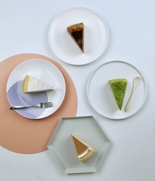 Four different slices of cake, set on plates.