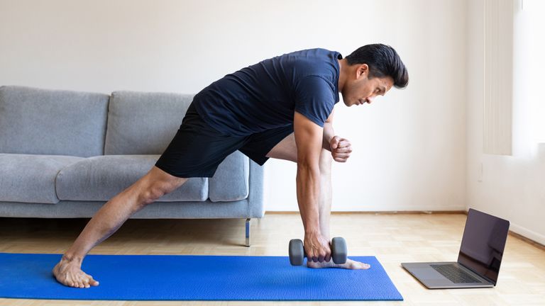 Man performing dumbbell row at home