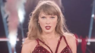 Taylor Swift serving to the camera in the red costume.