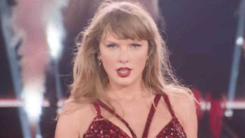 Taylor Swift serving to the camera in the red costume. 