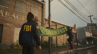 A town in Alan Wake 2 with residents putting up a banner that reads 'Deer Fest'
