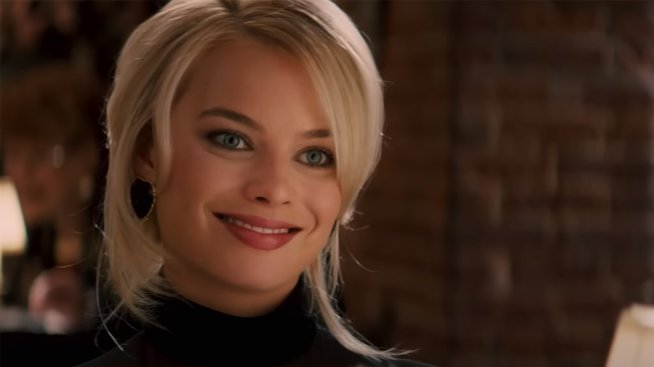 Margot Robbie sonríe a Leonardo DiCaprio en la cena de El lobo de Wall Street